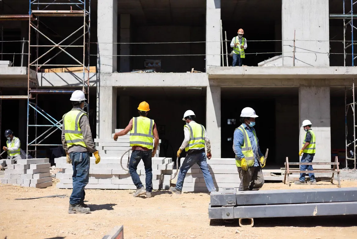 Active construction phase with skilled craftsmen coordinating installation, inspections, and vendors